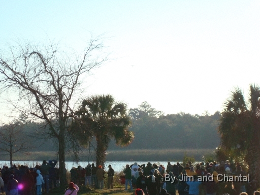  "The plane, the plane!"  All eyes, binoculars, scopes and recorders focus just over the tree-line on the St. Mark's River tidal marsh, as the first Operation Migration ultralight aircraft (upper-center) flies through the haze.  Whooping Crane flyover, St. Mark's, Florida, January 17, 2009.
